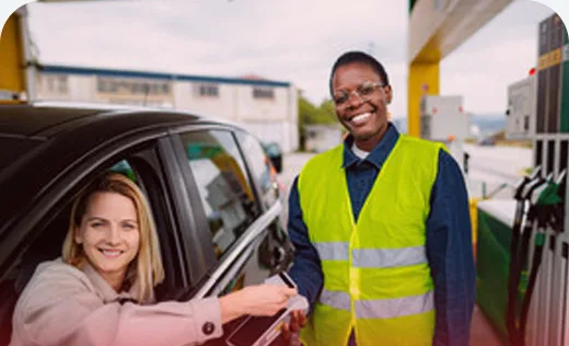 Petrol station attendant taking a card payment on a POS terminal